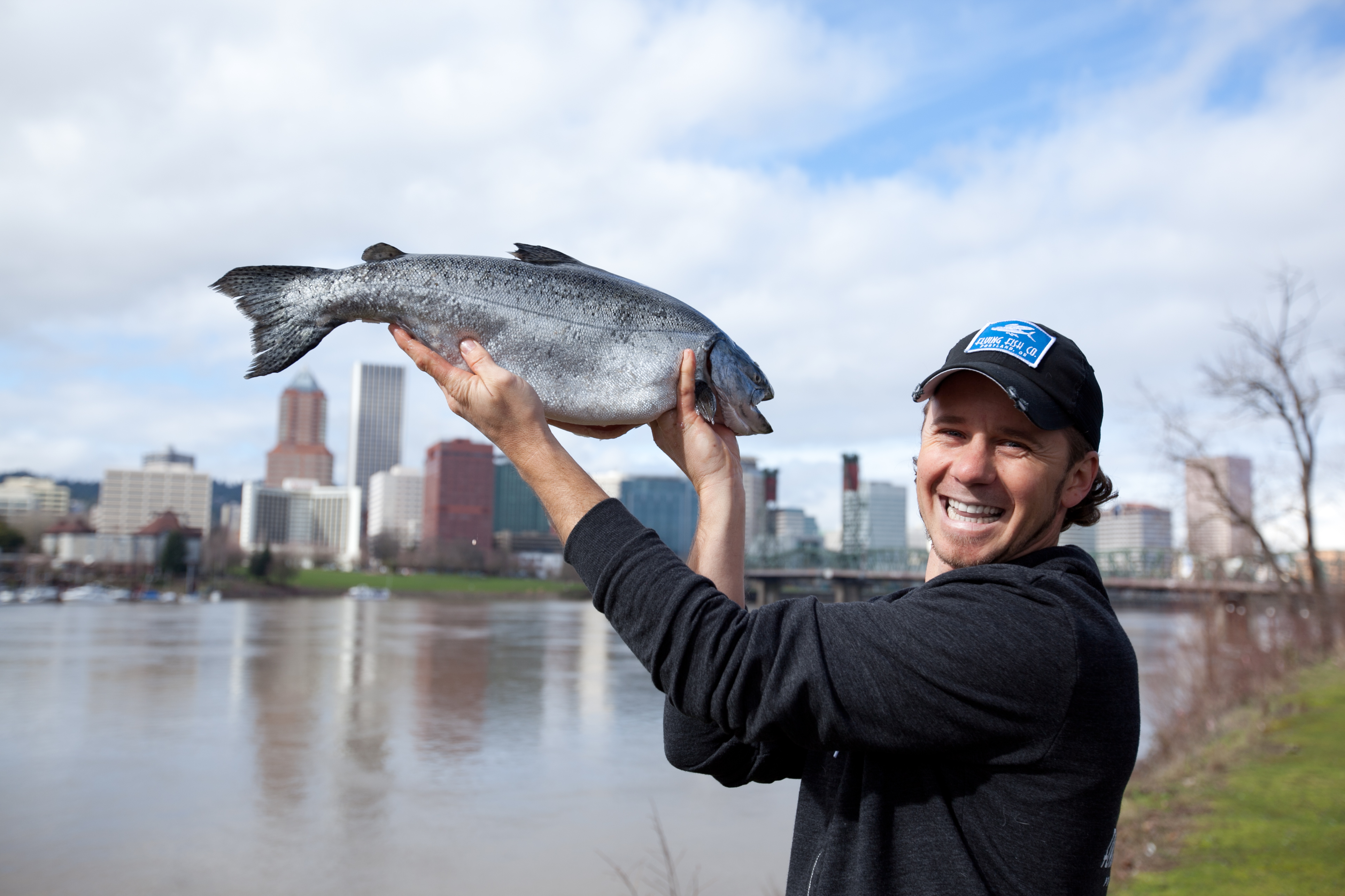 lyf holding salmon with portland in background